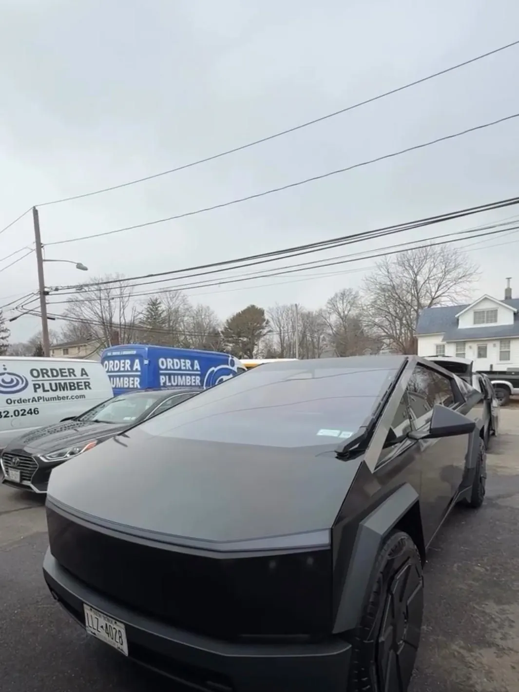 A Tesla Cybertruck wrapped in matte black vinyl outside the shop