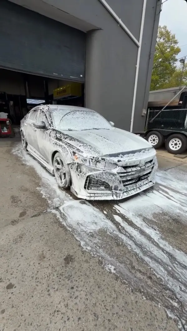 Sedan covered in snow foam pre-wash