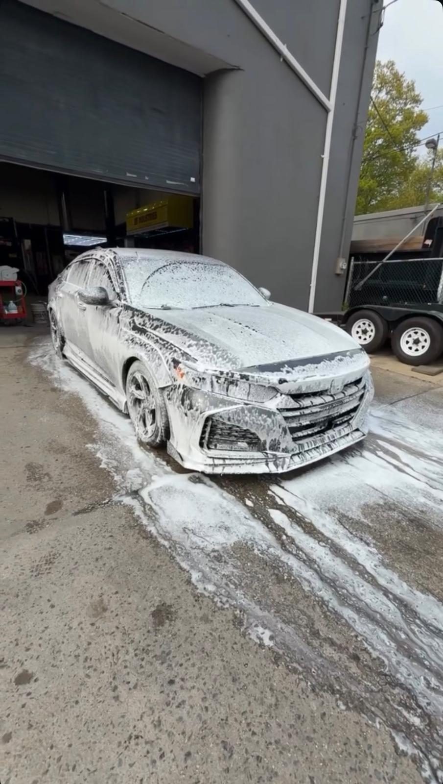 Sedan covered in snow foam pre-wash