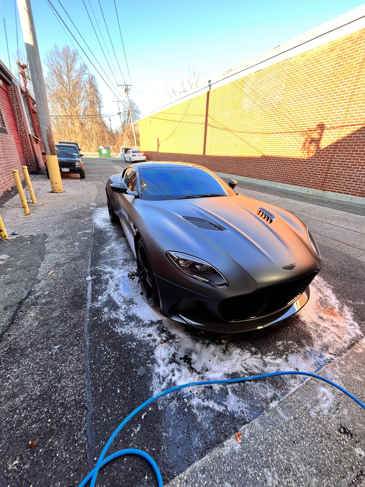 Matte black wrapped coupe getting foam washed